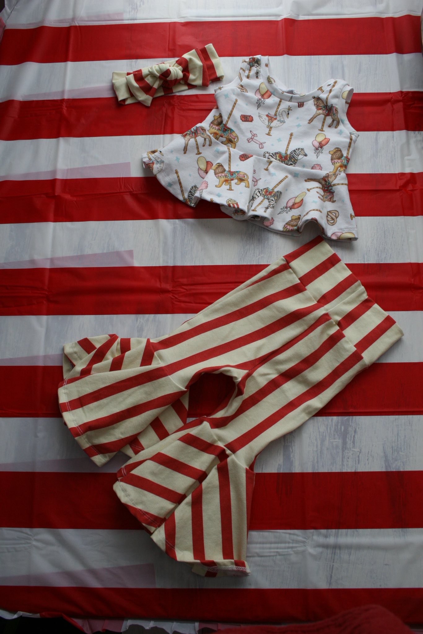 Baby girl peplum top and striped bell bottom pants set with matching headband featuring circus carousel print