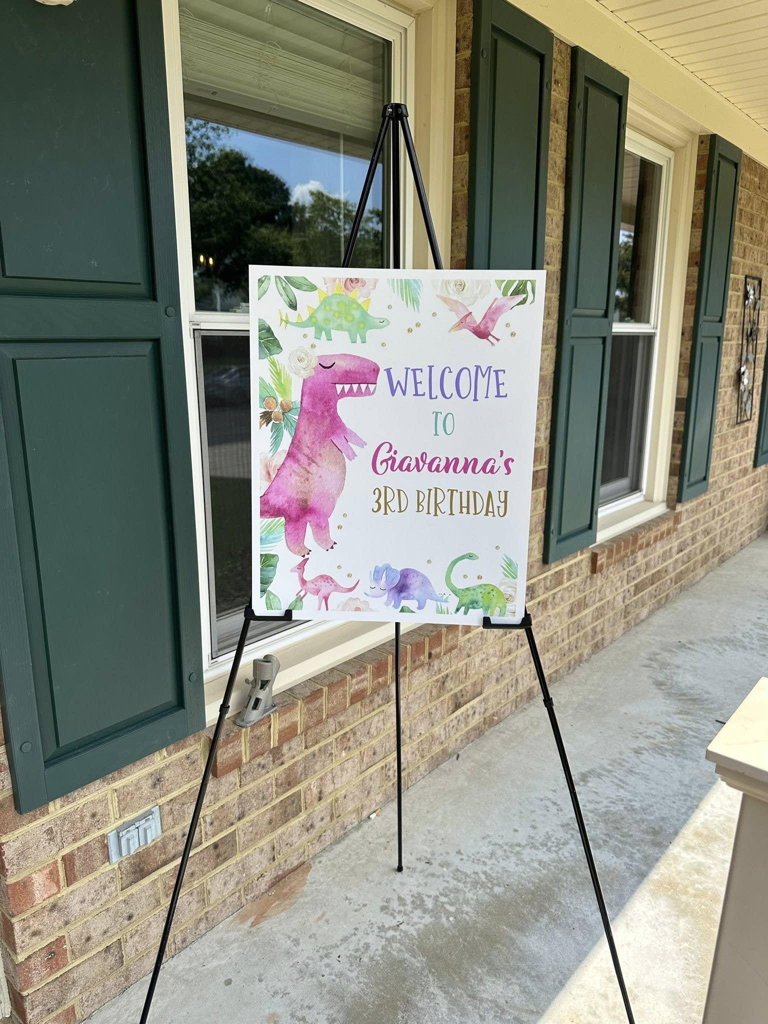 Personalized watercolor dinosaur birthday welcome sign on an easel for Giavanna's 3rd birthday.