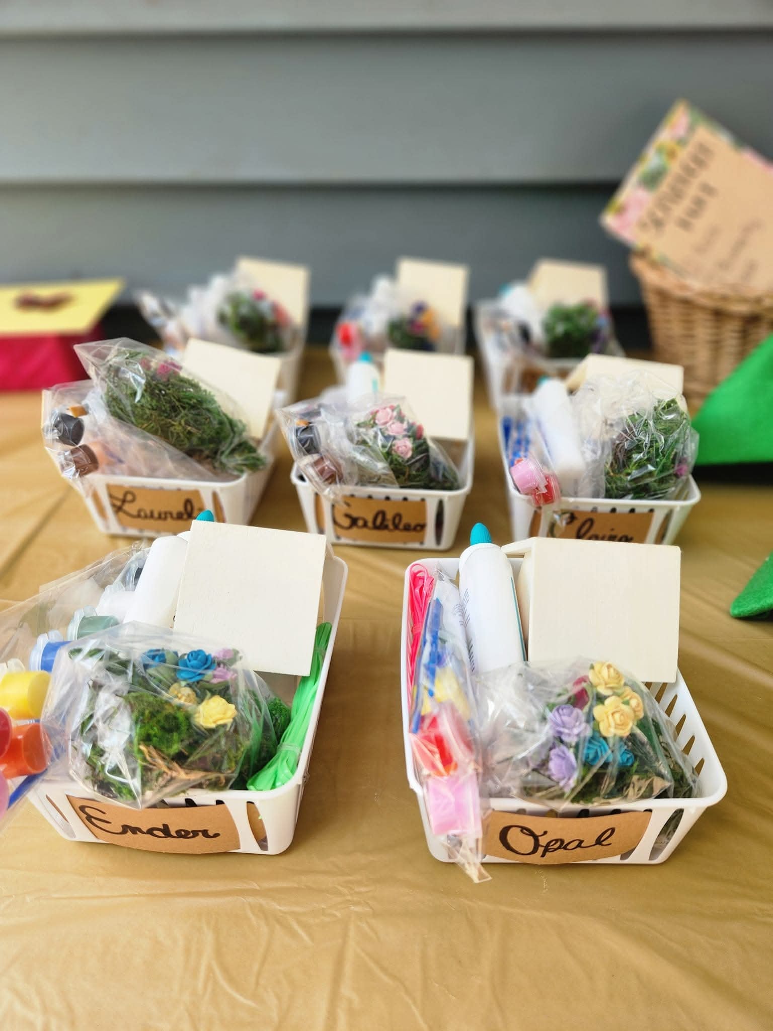 Personalized craft supply baskets for a craft party on a gold table