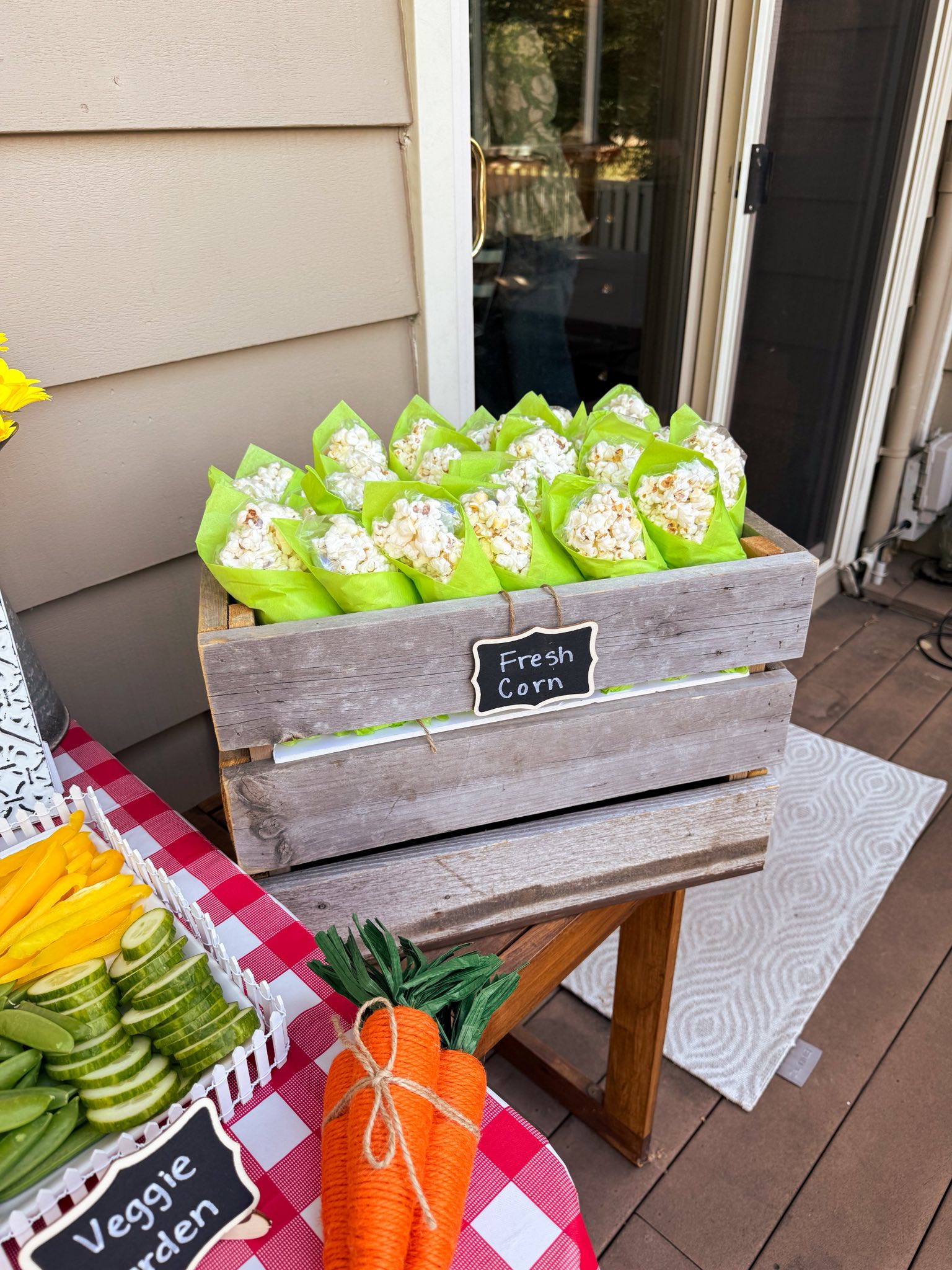 Crate labeled Fresh Corn filled with individual popcorn servings wrapped in lime green tissue paper