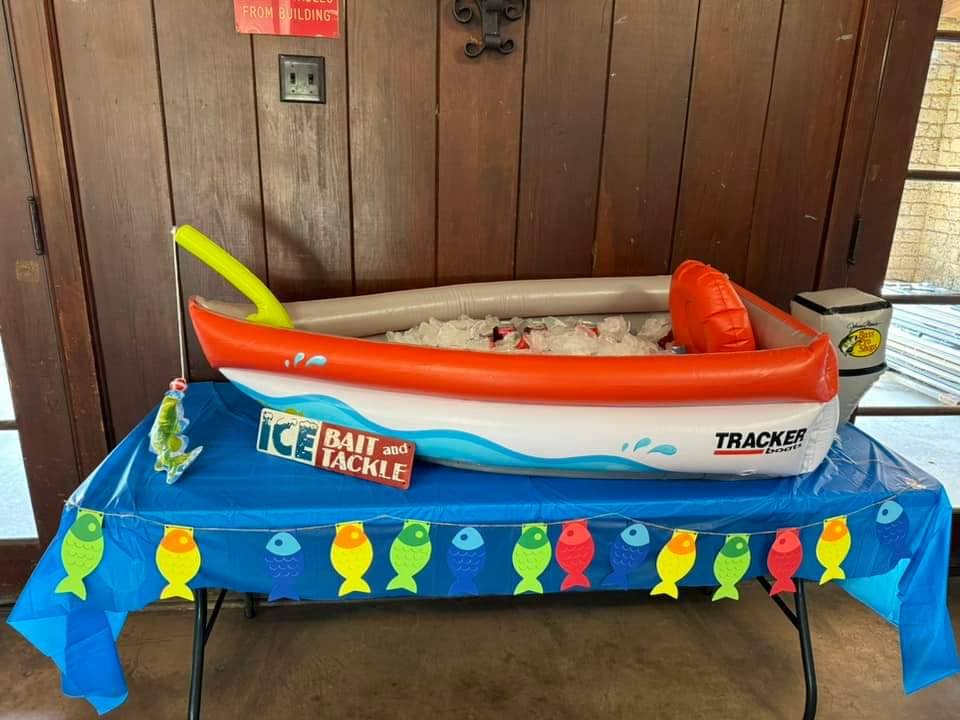 Inflatable Tracker boat party cooler on a table with fish decorations