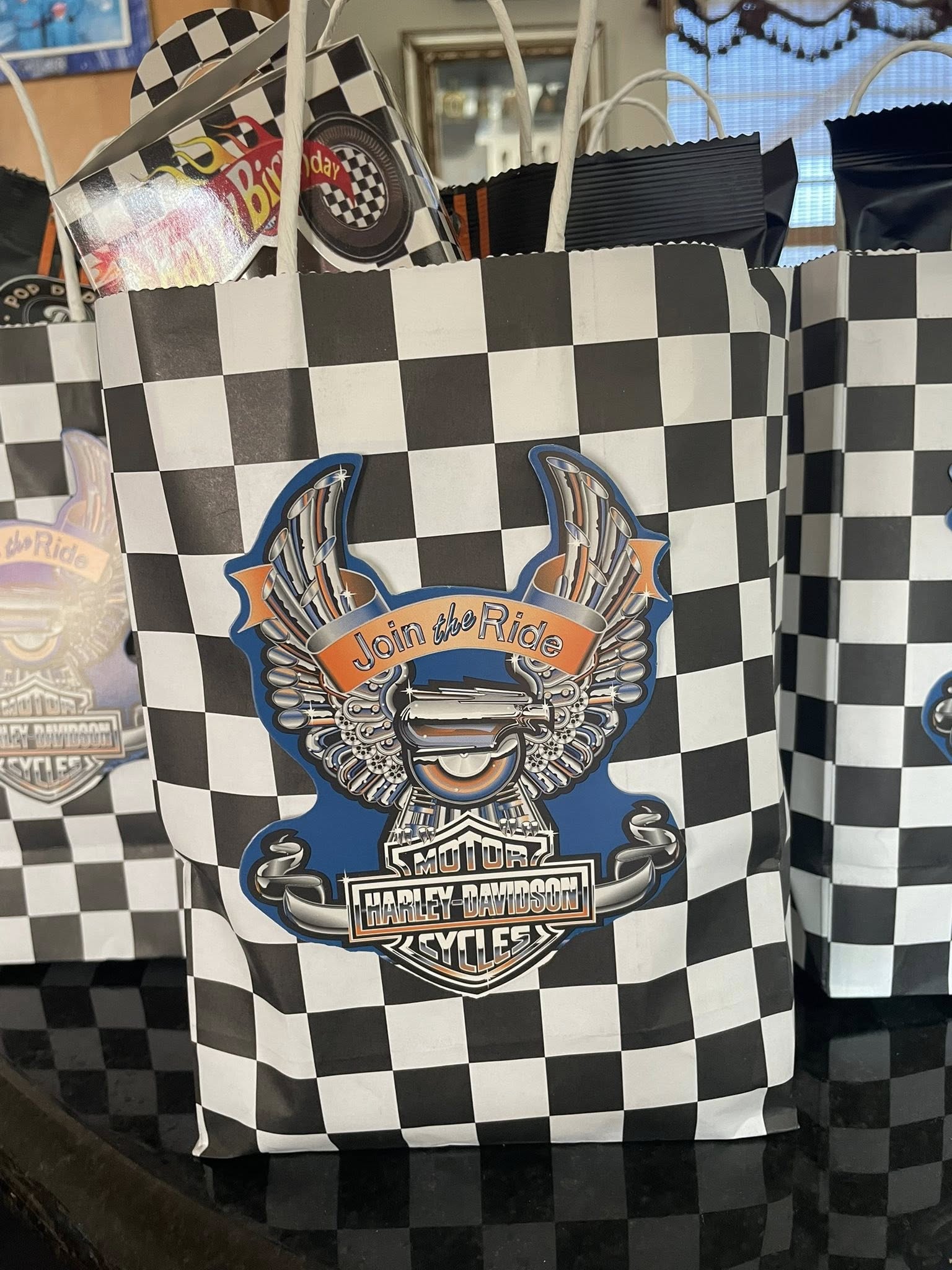 Black and white checkered party gift bags decorated with Harley-Davidson logo cutouts.