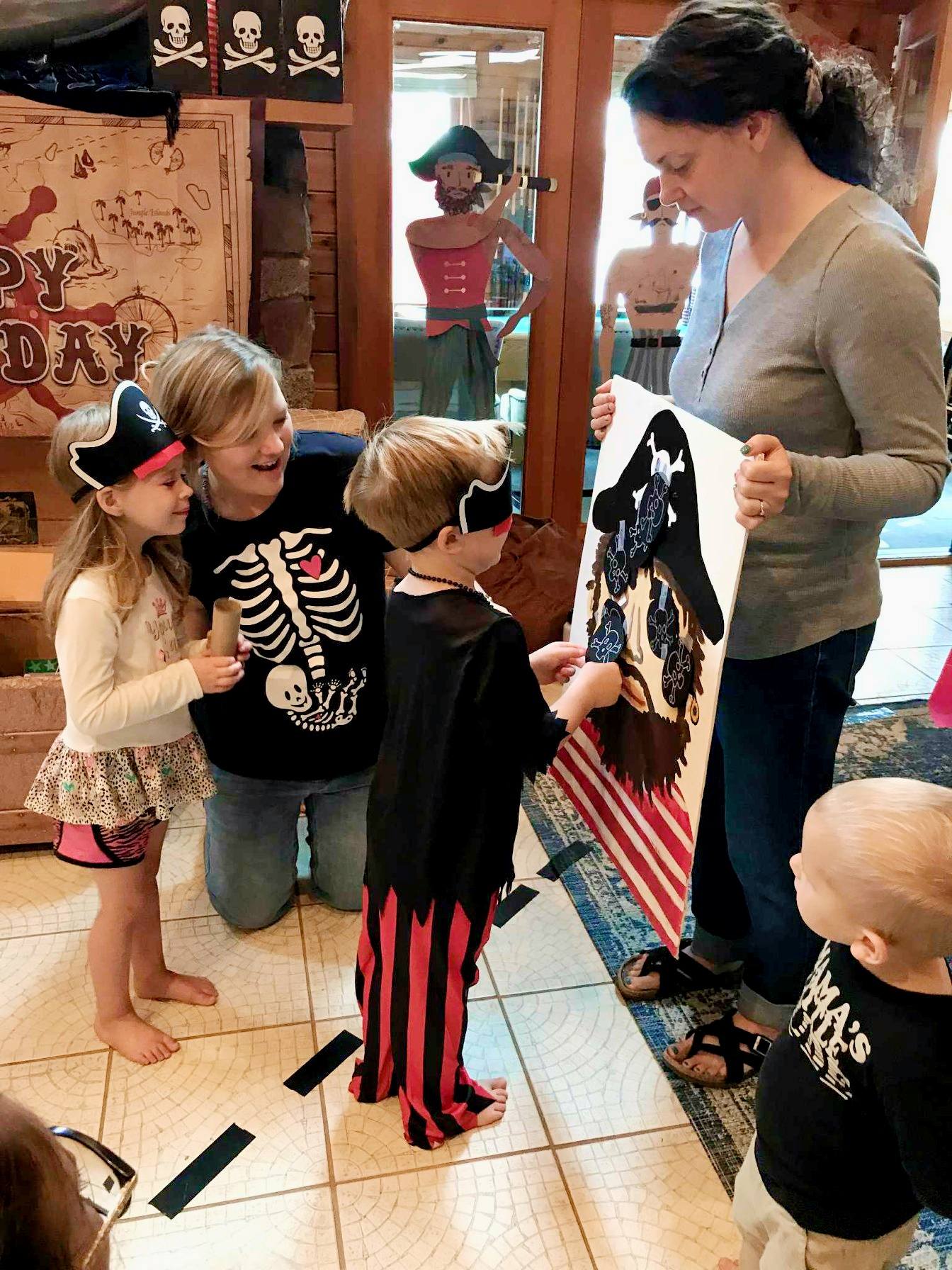 Children playing a pin the eyepatch on the pirate game at a party.