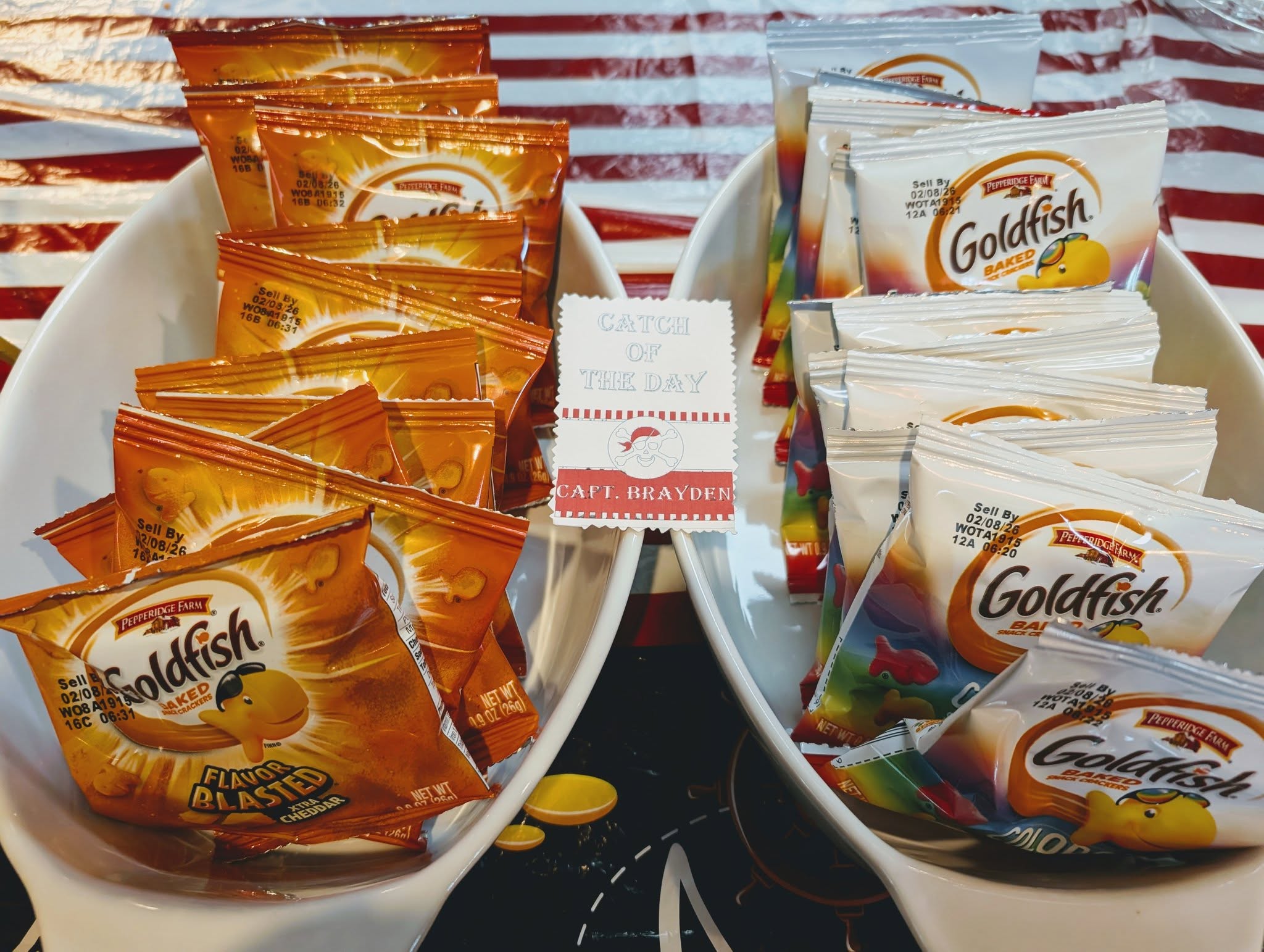 Two white bowls filled with Pepperidge Farm Goldfish snack cracker bags, with a Catch of the Day party sign.