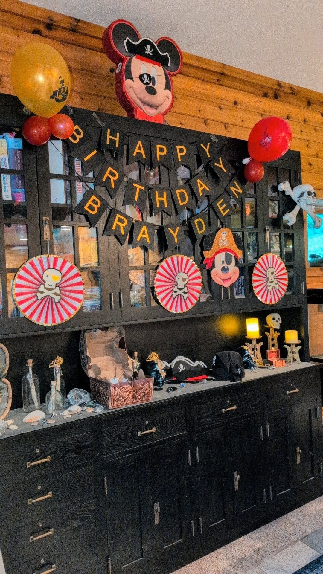 Pirate-themed birthday party decorations featuring Mickey Mouse, skull accents, and a Happy Birthday banner.