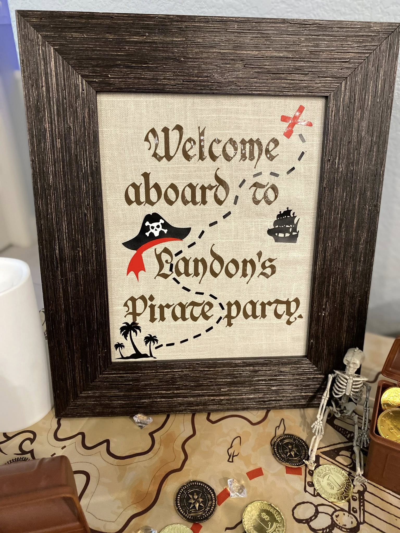 Framed welcome sign for Landon's pirate party on burlap style fabric
