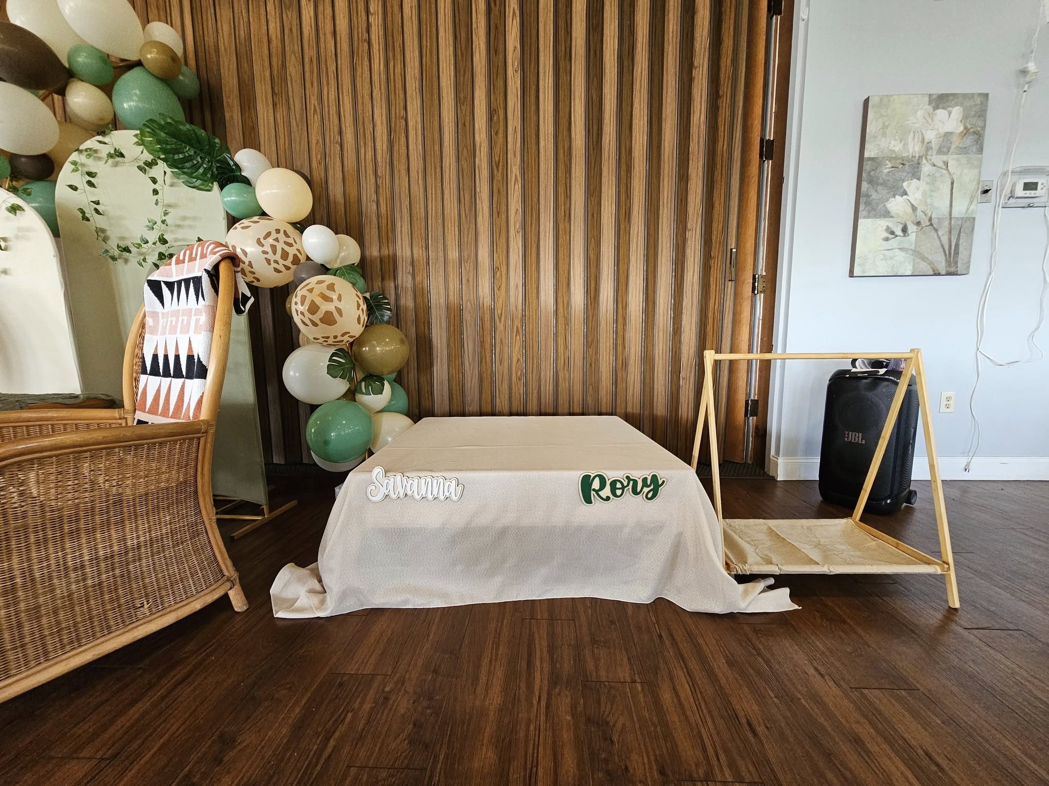 Table setting with green and wood-toned balloons and custom name signs for Savanna and Rory