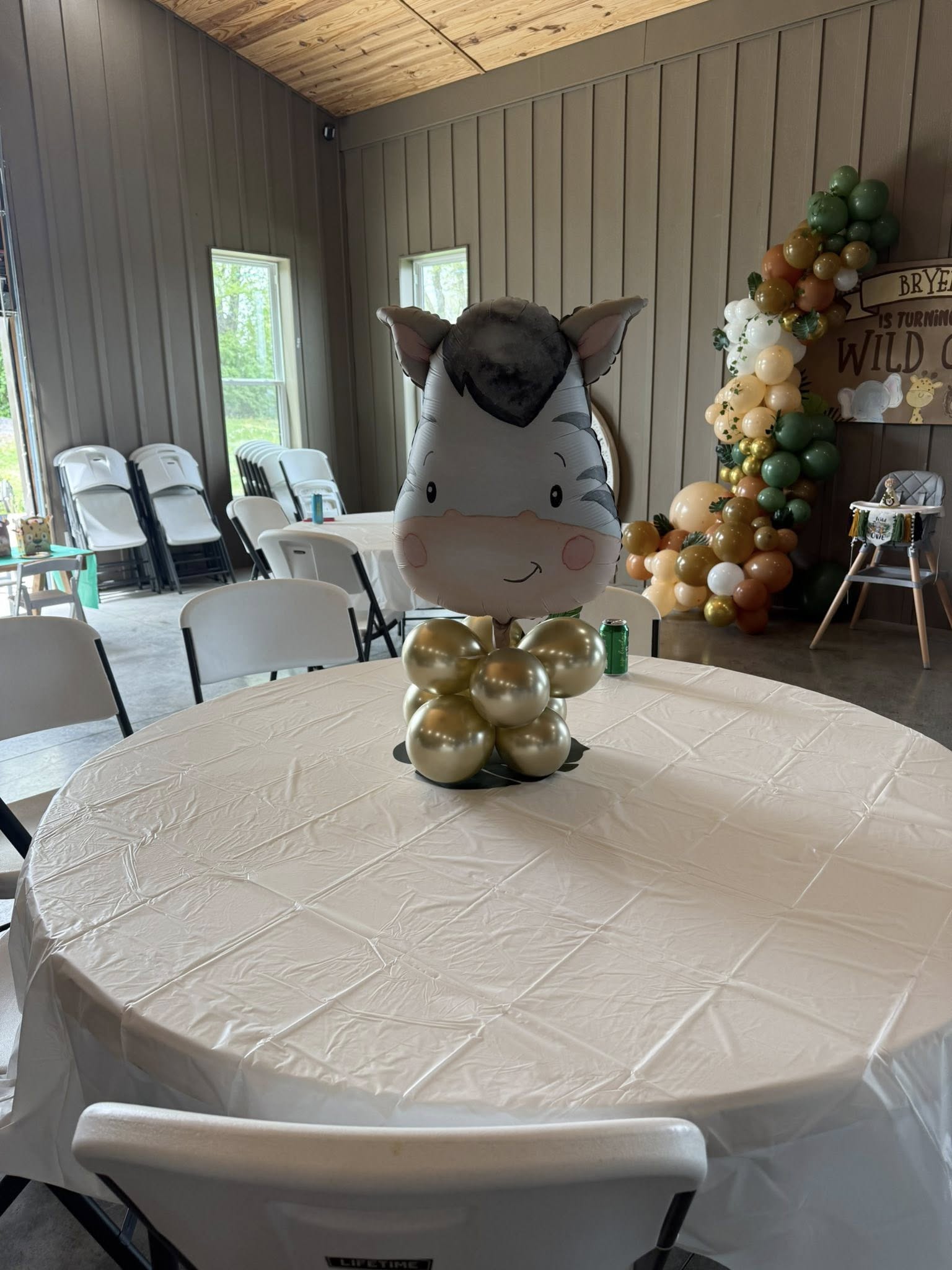 Zebra-shaped balloon centerpiece on a white tablecloth at a safari-themed birthday party.