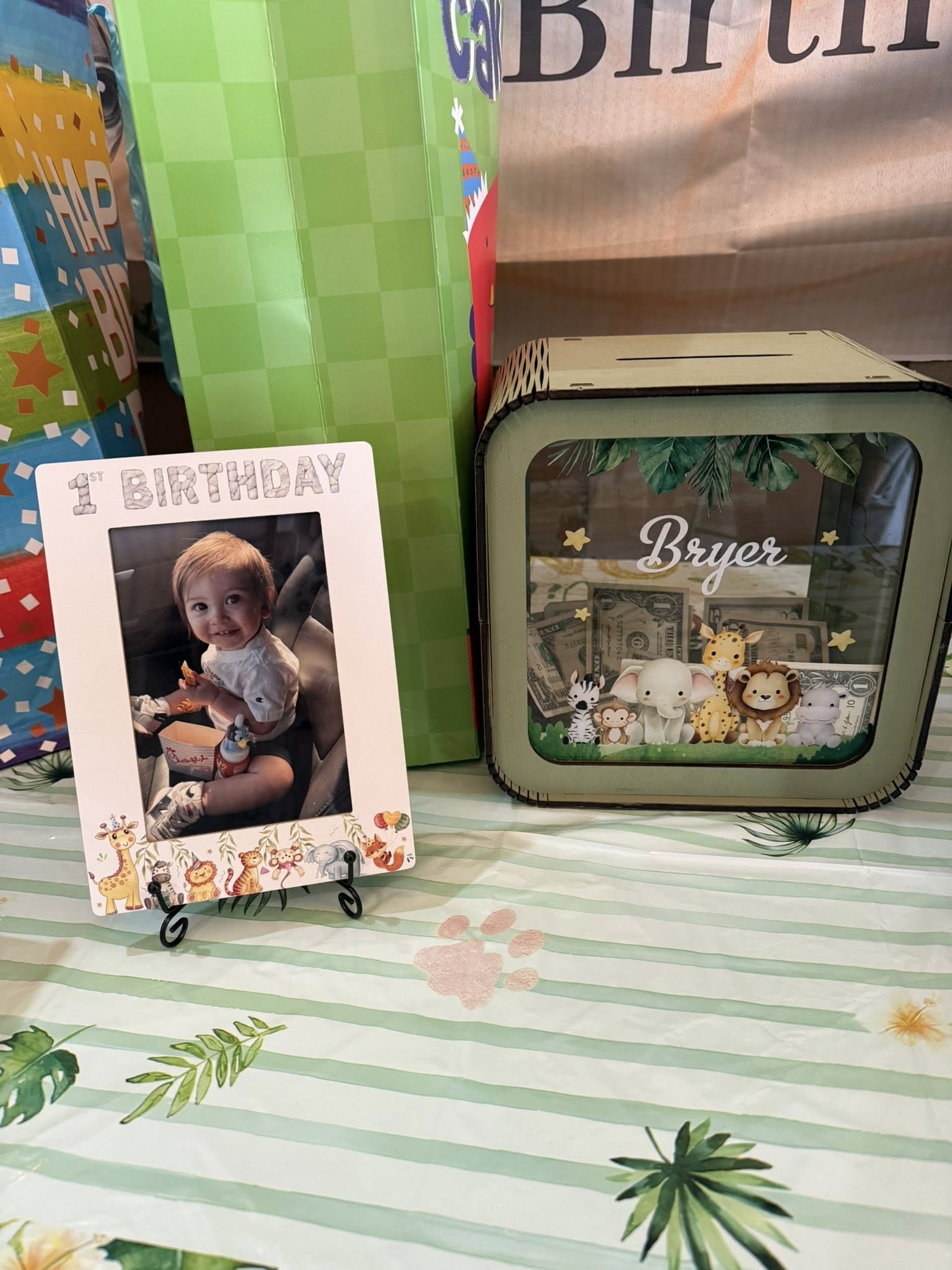 Personalized first birthday photo frame and matching jungle-themed money bank with name Bryer.