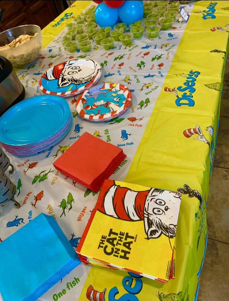 Table set for a party with Dr. Seuss The Cat in the Hat themed plates, napkins, and tablecloth.