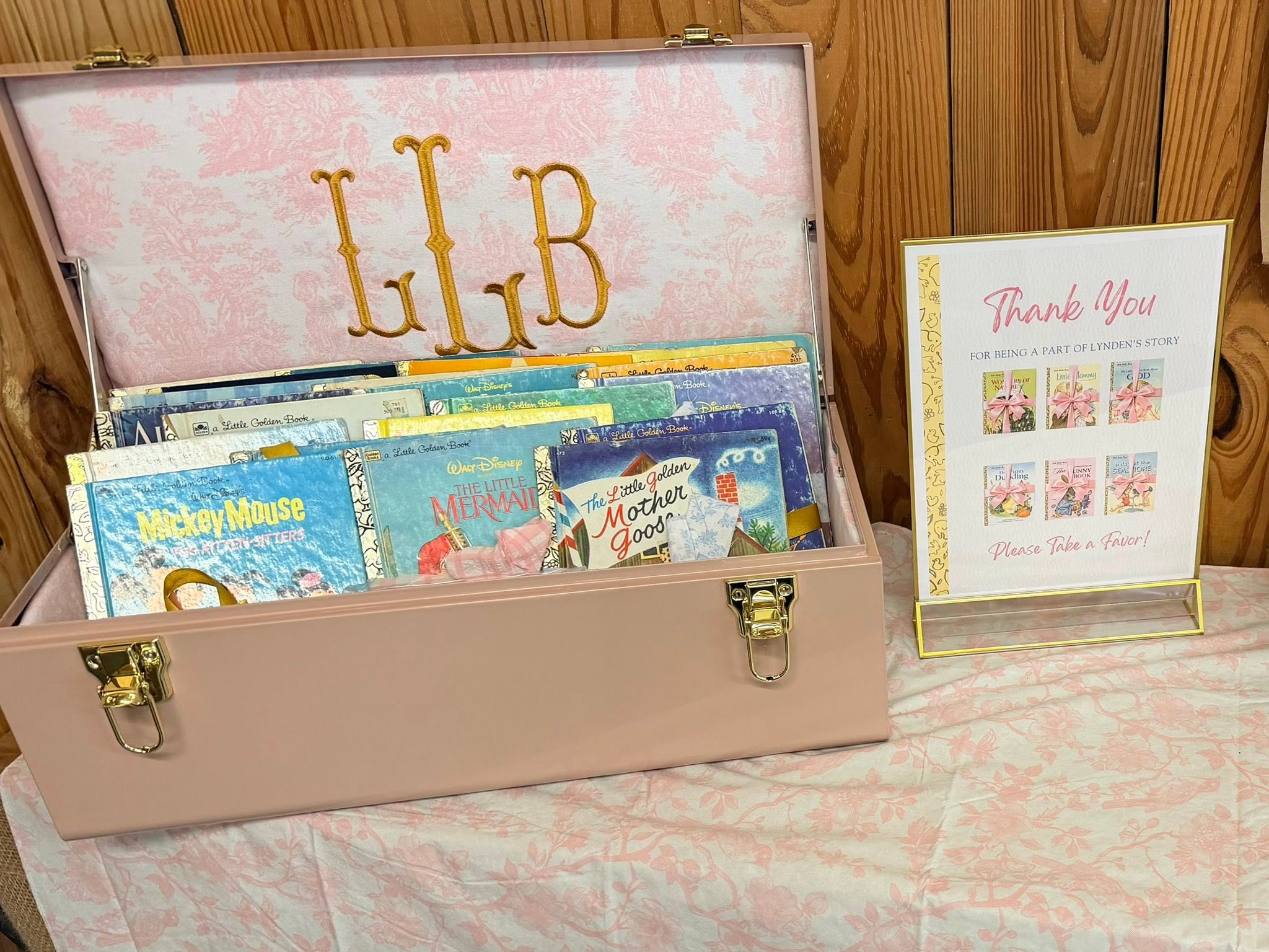 Personalized pink storage trunk filled with vintage Little Golden Books for party favors with a Thank You sign.