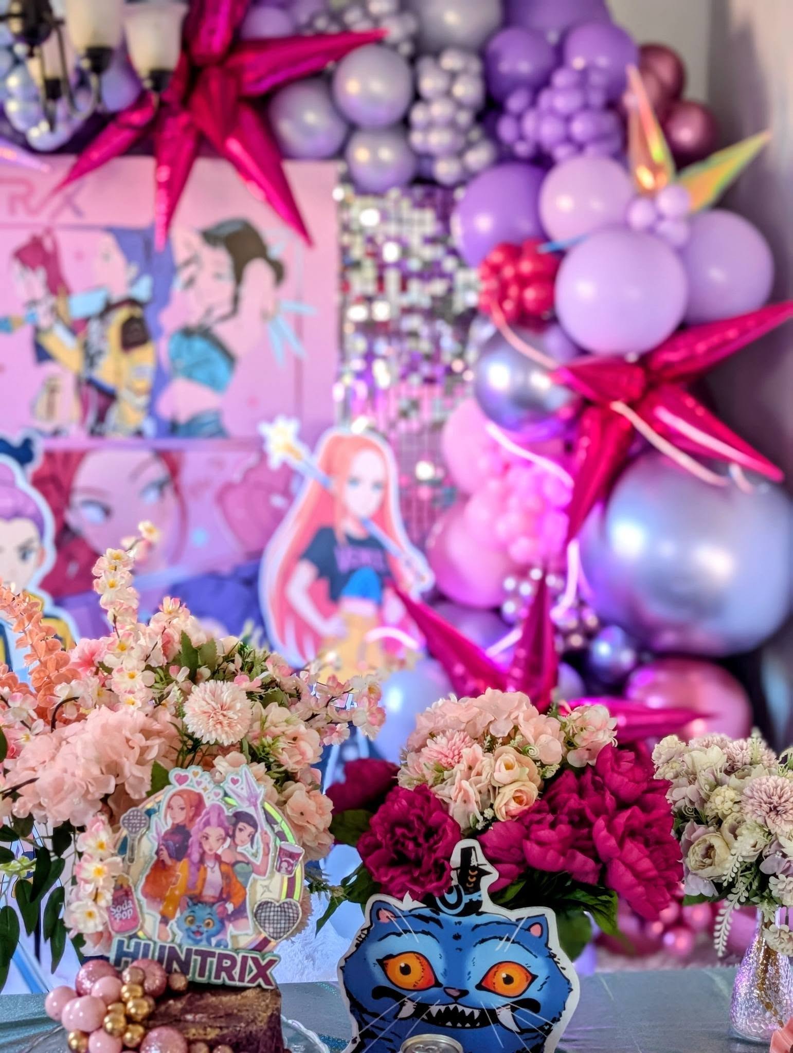 Winx Club themed event decorations with purple and pink star balloons and custom character centerpieces.