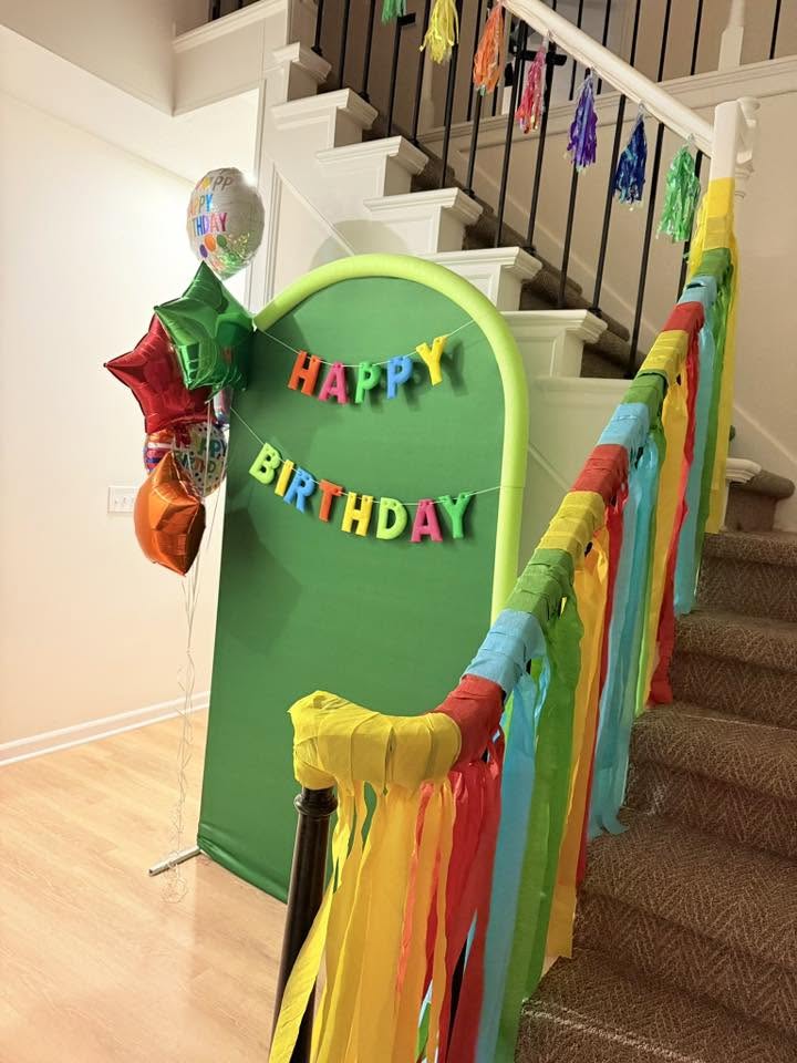 Birthday party backdrop with Happy Birthday banner and festive colorful balloons and streamers on a staircase