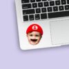 Custom Red Game-Hero Cap and Mustache Portrait Face Cutout – Sticker Custom Red Game-Hero Cap and Mustache Portrait Face Cutout shown on a sticker mockup